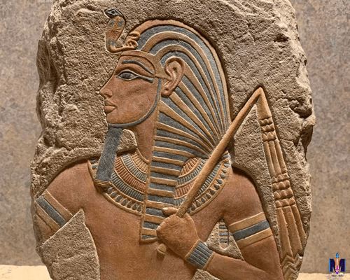 Egyptian stone relief of a pharaoh with traditional headdress and crook, showcasing symbolic power and divine authority in ancient Egyptian art.
